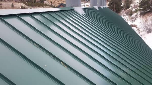 Standing seam metal roof installation in winter conditions by Peakline Roofing in Calgary