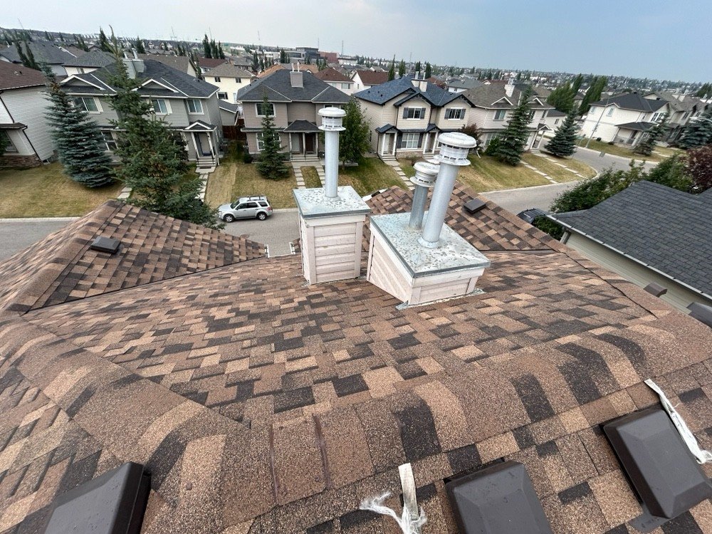 Aerial view of a completed asphalt shingle roof replacement in a Calgary neighbourhood by Peakline Roofing