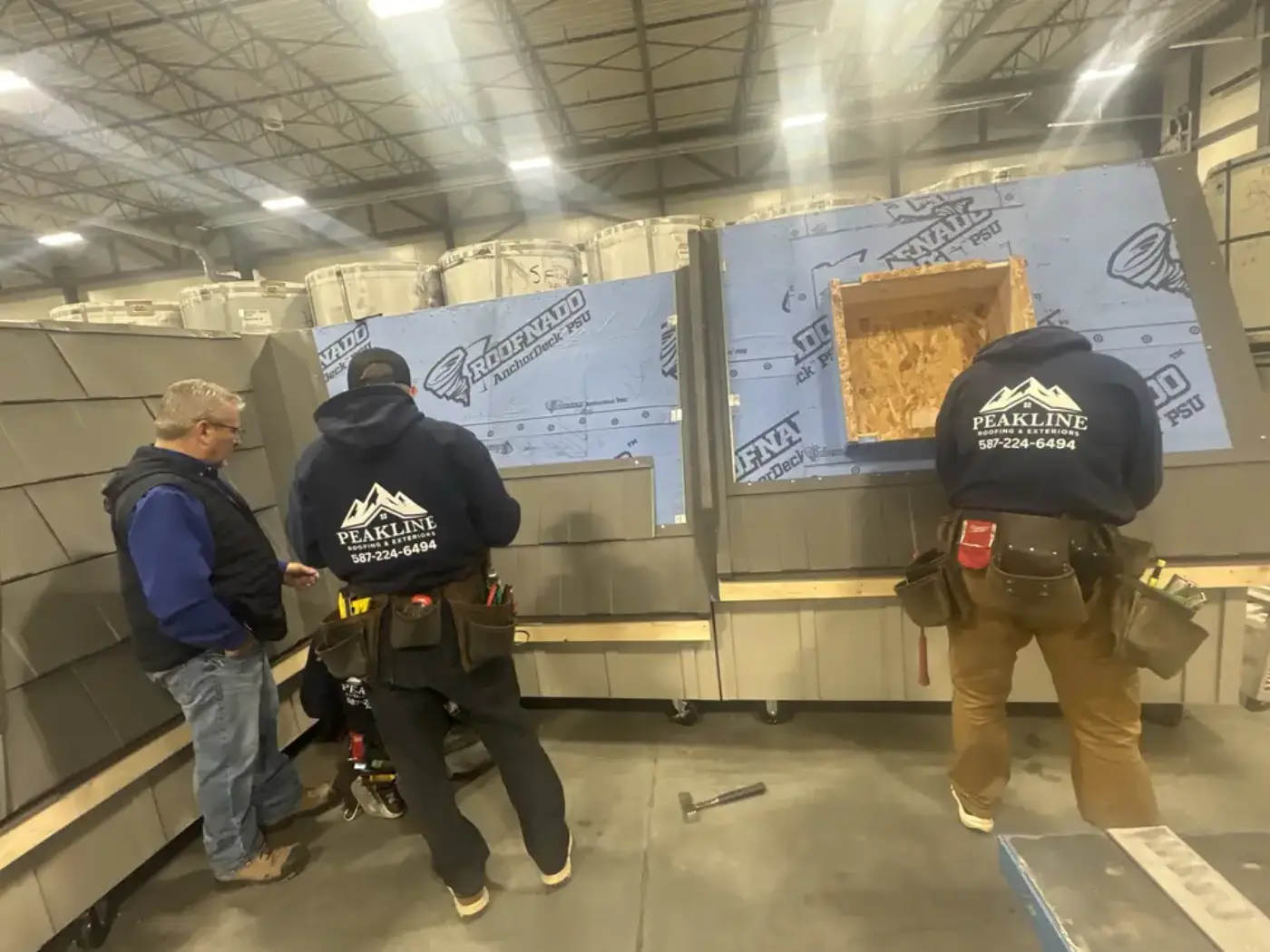 Peakline Roofing & Exteriors crew training in branded uniforms at professional facility