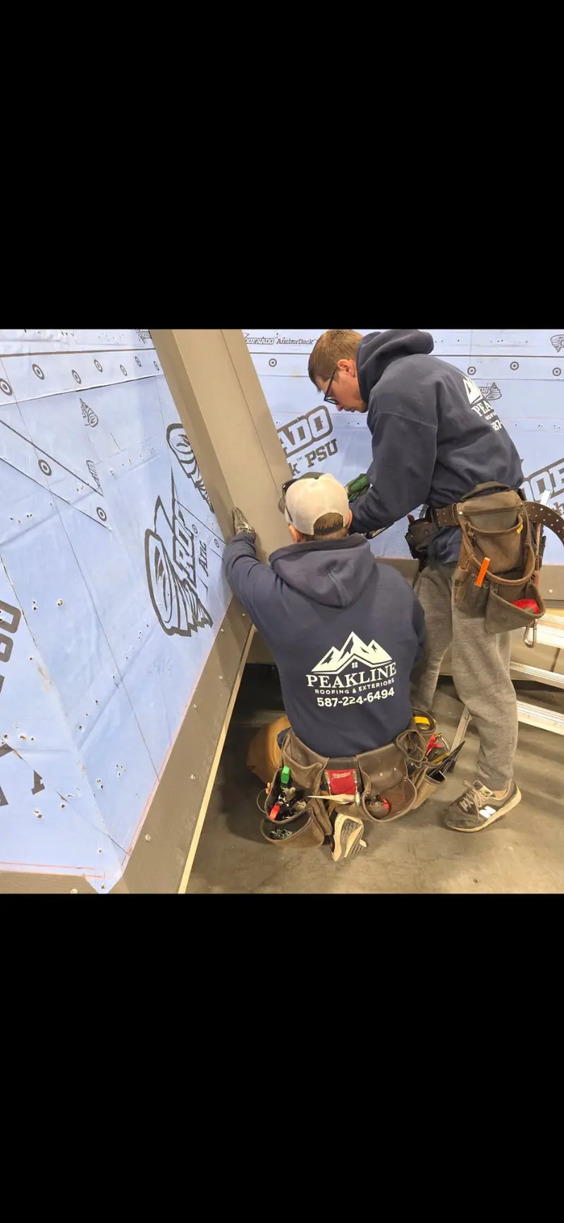 Peakline Roofing crew members working on underlayment and flashing techniques during training