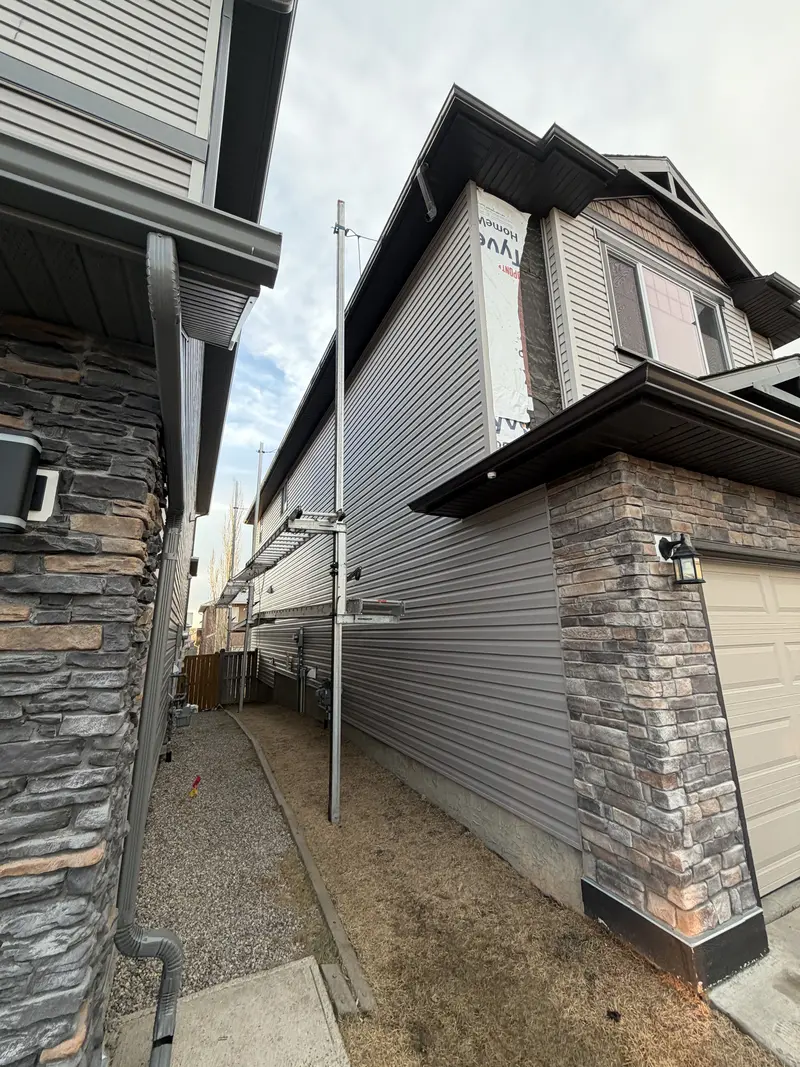 Completed siding installation with stone accents on Calgary home by Peakline Roofing & Exteriors